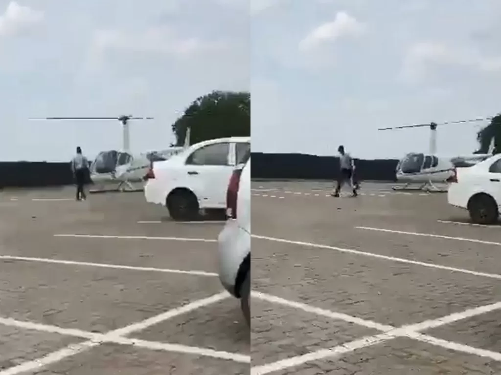 Seorang mahasiswa yang mengambil tasnya saat diantar memakai helikopter. (photo/Twitter/@ItuhMokhele)