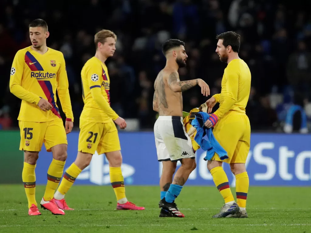 Penyerang Barcelona, Lionel Messi bertukar jersey dengan pemain Napoli selepas laga. (REUTERS/Ciro De Luca)