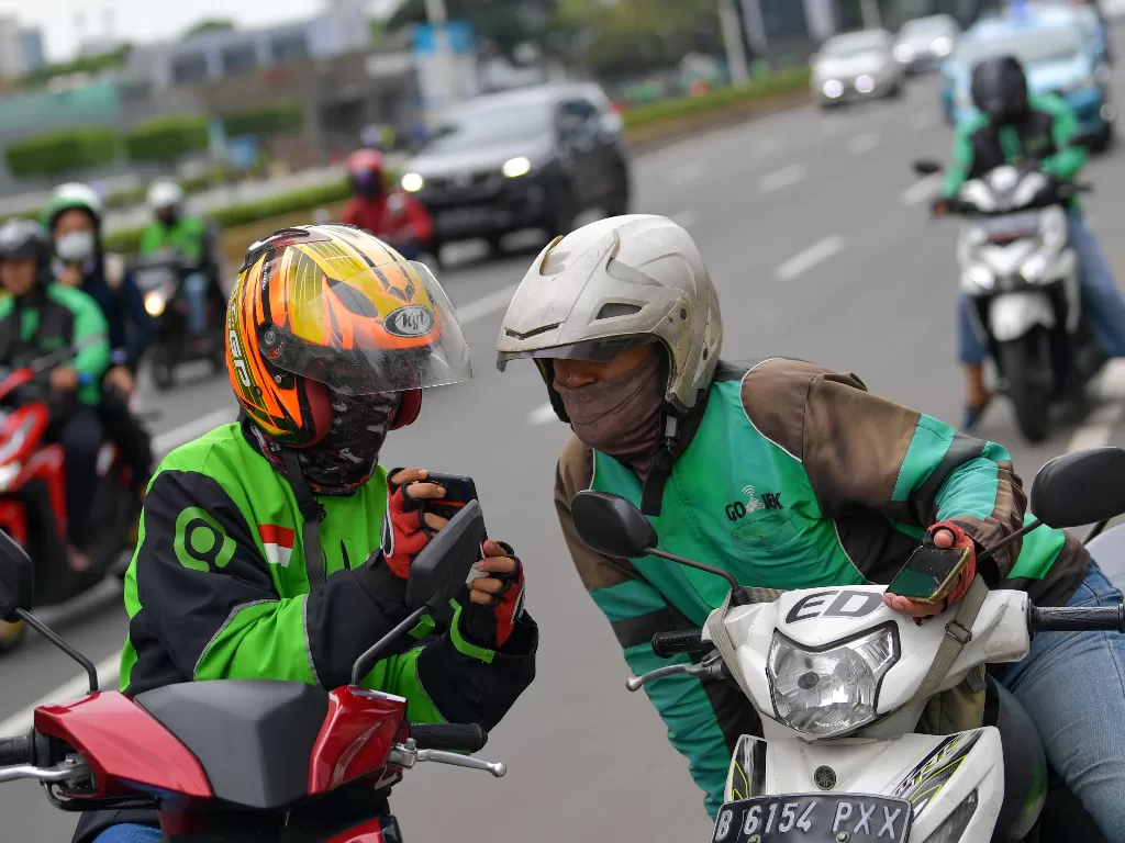 Dua orang pengemudi ojek online berbincang di Jalan Thamrin, Jakarta, Senin (17/2/2020). (ANTARA FOTO/M Risyal Hidayat)