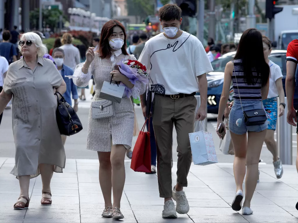 Sepasang suami istri merayakan Hari Valentine ketika mereka mengenakan masker di Orchard Road di Singapura. (photo/REUTERS/Edgar Su)