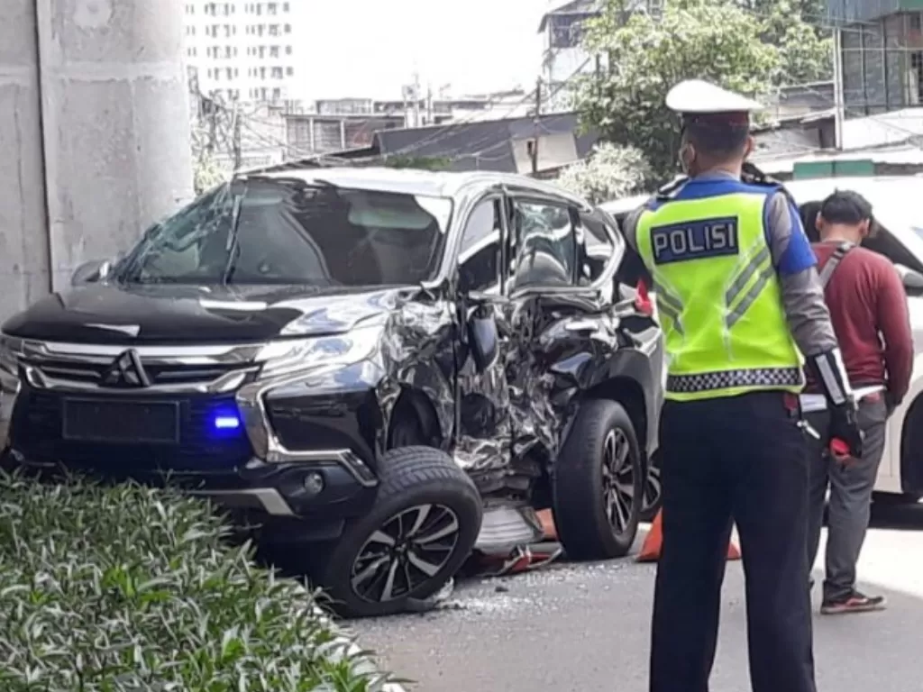 Petugas kepolisian mengamankan lokasi tabrakan antara mobil pribadi dengan TransJakarta di Jalan Sultan Iskandar Muda, Kebayoran Lama, Jakarta Selatan, Selasa (10/3/2020). (ANTARA/Taufik Ridwan)