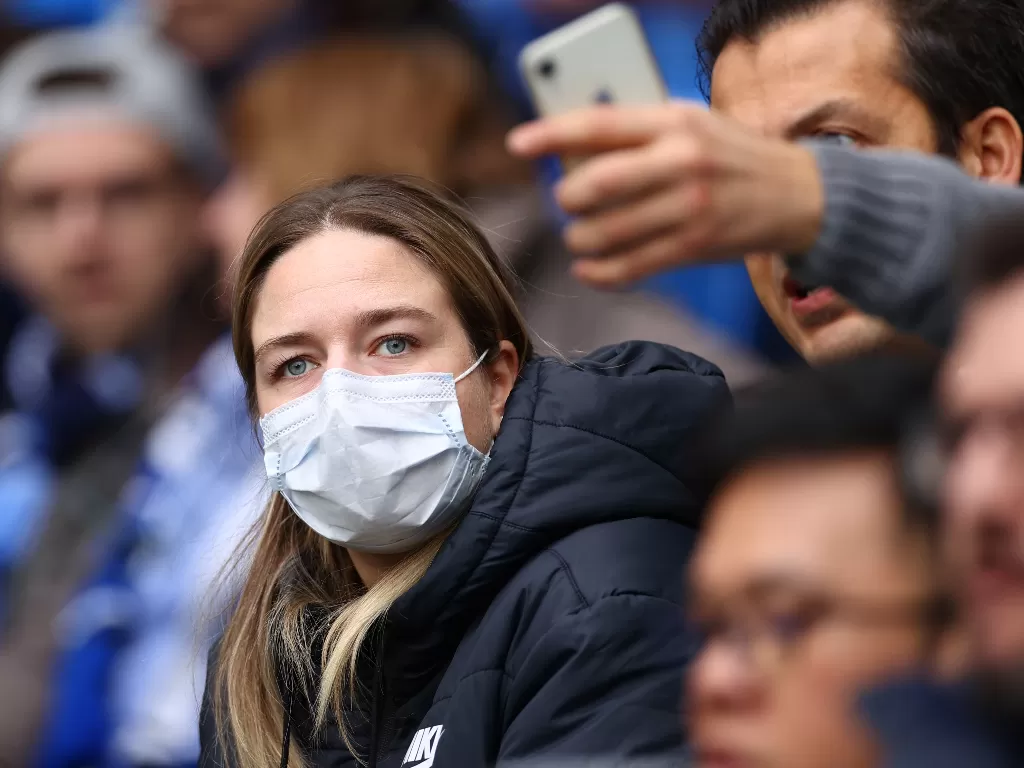 Suporter memakai masker akibat wabah virus Corona. (REUTERS/Kai Pfaffenbach)