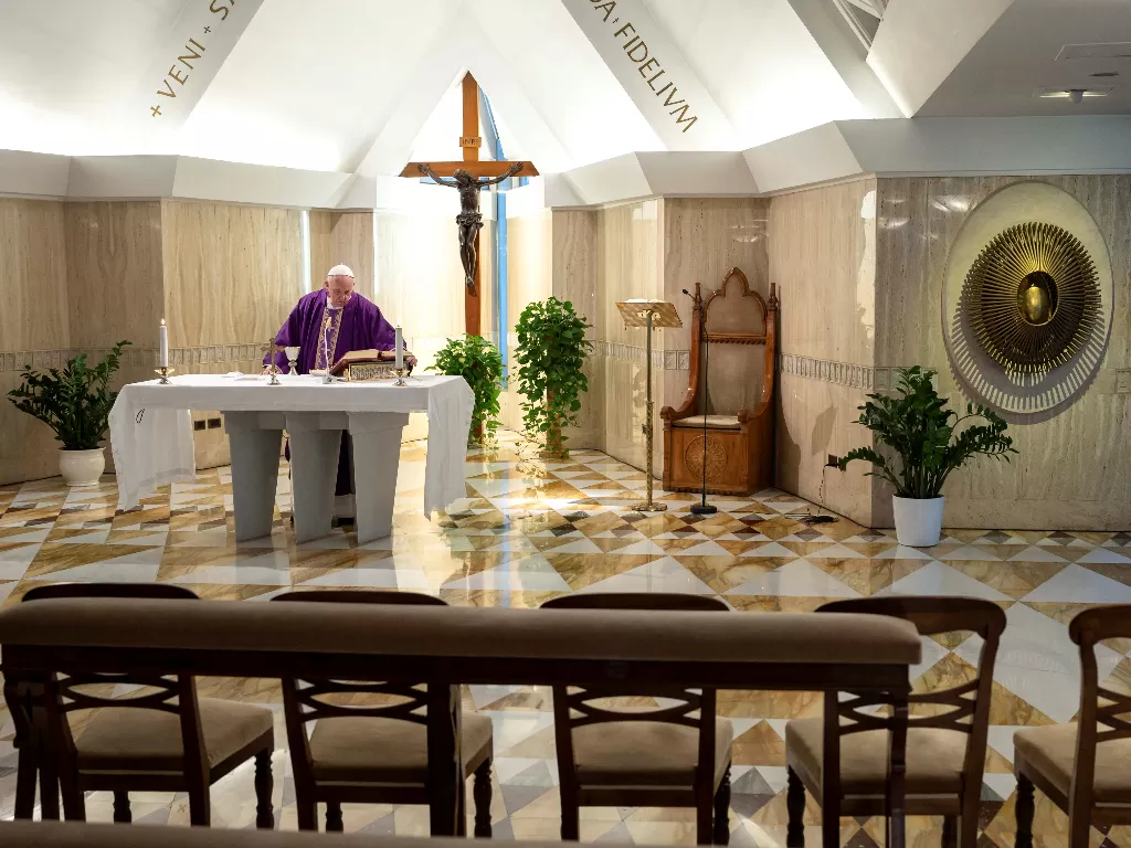 Paus Fransiskus memimpin misa melalui siaran langsung video di sebuah kapel dengan bangku kosong di St. Martha House di Vatikan, Selasa (10/3/2020). (Vatican Media/Handout via REUTERS)