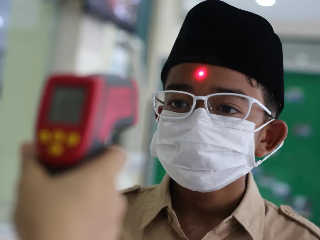 Siswa sekolah menjalani pemeriksaan suhu tubuh sebelum memasuki lingkungan sekolah di SMP Al-Bayan Islamic School di Jakarta Barat, Rabu (11/3/2020). (ANTARA FOTO/Fauzan)