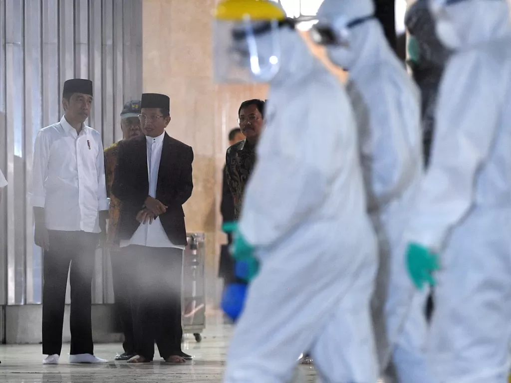 Presiden Joko Widodo (kiri) meninjau pembersihan Masjid Istiqlal dengan cairan desinfektan di Jakarta Pusat, Jumat (13/3/2020). (ANTARA FOTO/Sigid Kurniawan)