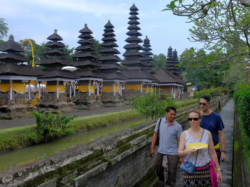 Pemandu wisata memberi penjelasan kepada turis asing di kawasan obyek wisata Pura Taman Ayun, Badung, Bali, Kamis (12/3). (ANTARA FOTO/Nyoman Hendra Wibowo)