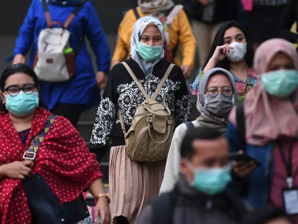 Calon pengguna transportasi umum mengenakan masker saat melintasi kawasan Terowongan Kendal, Jakarta, Kamis (12/3/2020). (photo/ANTARA/Wahyu Putro A)