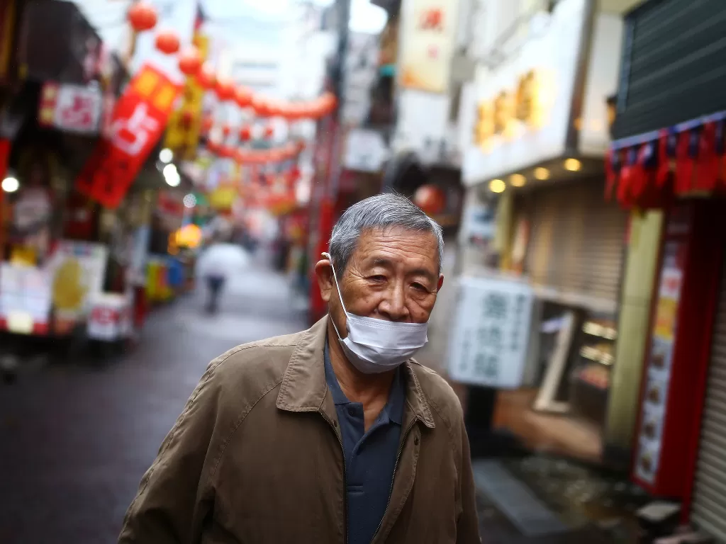 Ilustrasi - seorang pria, mengenakan masker setelah wabah penyakit COVID-19 di Tokyo. (photo/REUTERS/Edgard Garrido)