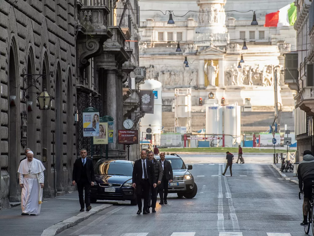 Paus Fransiskus berjalan menyusuri jalanan Roma yang sepi gara-gara wabah corona (Vatican Media/Handout via REUTERS)