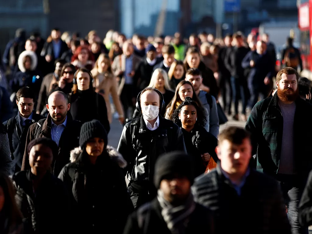 Orang-orang mengenakan masker pelindung, berjalan di jalan London Bridge, London. (photo/REUTERS/Henry Nicholls)