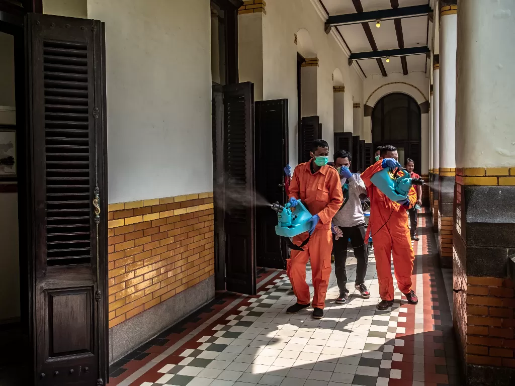  Petugas menyemprotkan cairan disinfektan di kawasan wisata Museum Cagar Budaya Lawang Sewu, Semarang, Jawa Tengah, Minggu (15/3/2020). (ANTARA FOTO/Aji Styawan)