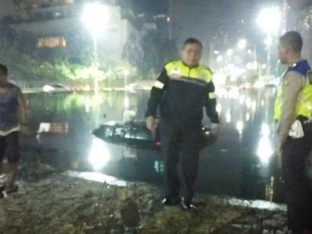Polisi di lokasi mobil tercebur di kolam Bundaran HI. (TMC Polda Metro Jaya)