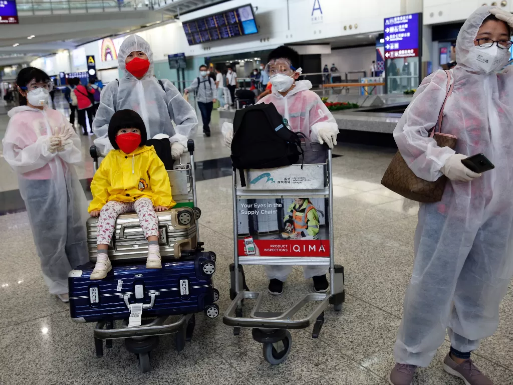 Penumpang mengenakan pakaian pelindung, di Bandara Internasional Hong Kong. (photo/REUTERS/Tyrone Siu)