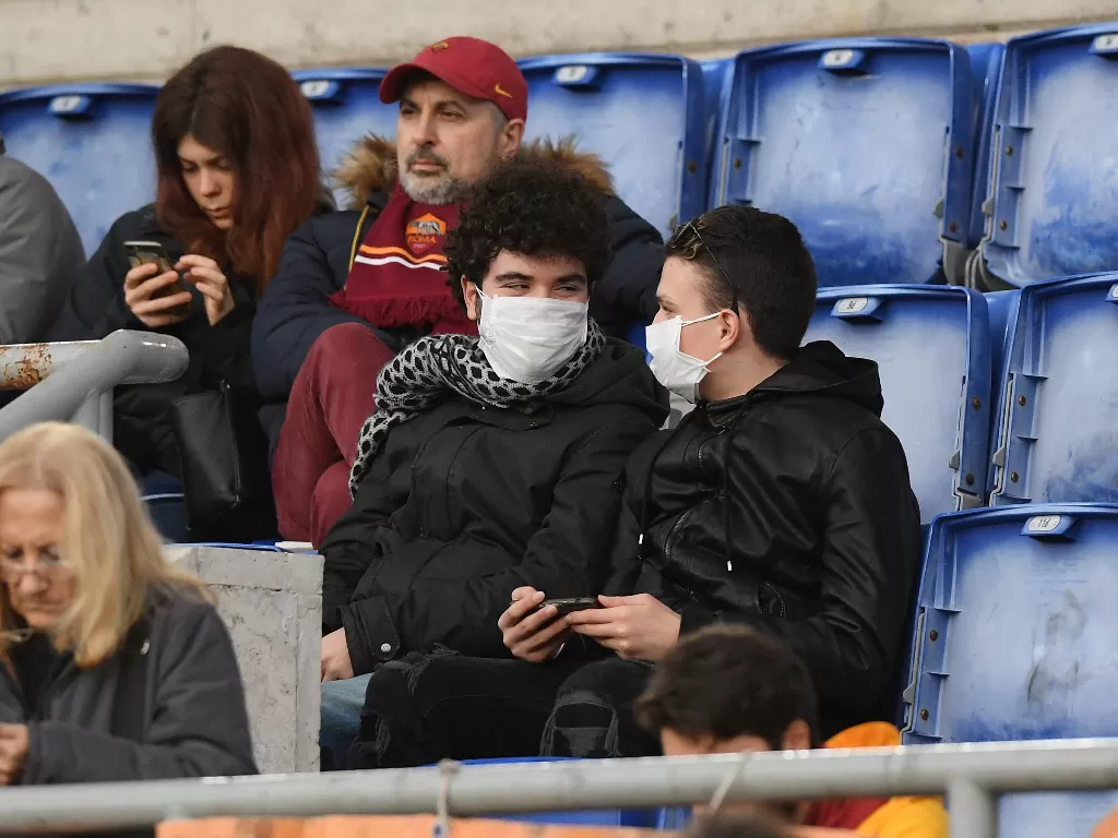 Suporter AS Roma memakai masker di Stadion. (REUTERS/Alberto Lingria)