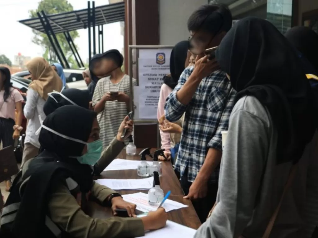 Petugas dari Dinas Polisi Pamong Praja Kota Sukabumi, Jawa Barat saat mendata puluhan pelajar yang terjaring razia Penegakan Surat Edaran Wali Kota tentang Pencegahan COVID-19 pada Rabu, (18/3). (Antara/Aditya Rohman)