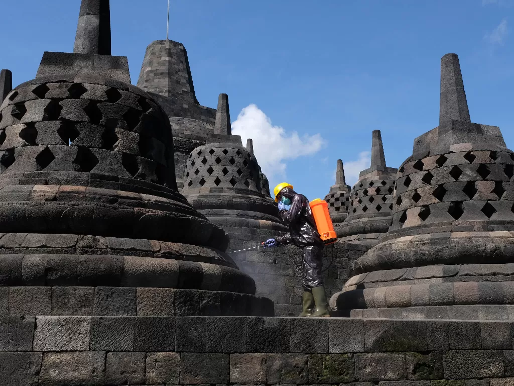 Petugas Balai Konservasi Borobudur (BKB) menyemprotkan cairan disinfektan di candi Borobudur Magelang, Jawa Tengah, Senin (16/3). (ANTARA FOTO/Anis Efizudin)