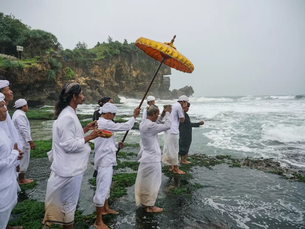 Umat Hindu melakukan prosesi mendak tirta atau mengambil air suci saat upacara Melasti di Pantai Ngobaran, Saptosari, Gunungkidul, DI Yogyakarta, Senin (9/3). (ANTARA FOTO/Hendra Nurdiyansyah)