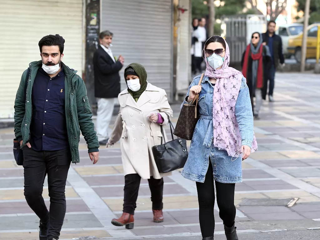 Orang-orang Iran memakai masker guna mencegah penyebaran virus corona (WANA/Nazanin Tabatabaee via REUTERS)