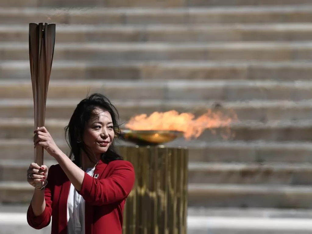 Naoko Imoto, pemenang Olimpiade Atlanta 1996, memegang obor dengan api Olimpiade Tokyo di Stadion Panathenaic, di Athena, Yunani, pada 19 Maret 2020 (Xinhua)