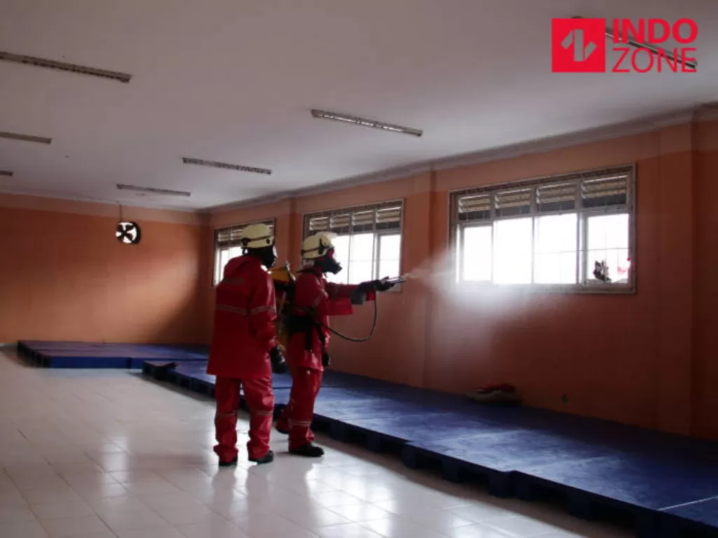 Petugas Pemadam Kebakaran (Damkar) menyemprotkan cairan disinfektan di Panti Sosial Bina Laras Harapan Sentosa 2, Cipayung, Jakarta Timur, Jumat (20/3/2020). (INDOZONE/Febio Hernanto)