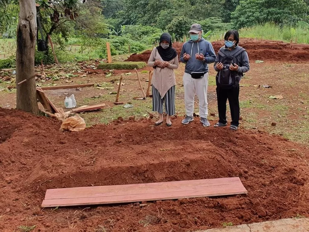 Saat pemakaman san ibu. Eva Rahmi Salama bersama saudaranya tanpa kehadiran sanak saudara. (Instagram/EvaRahmiSalama)