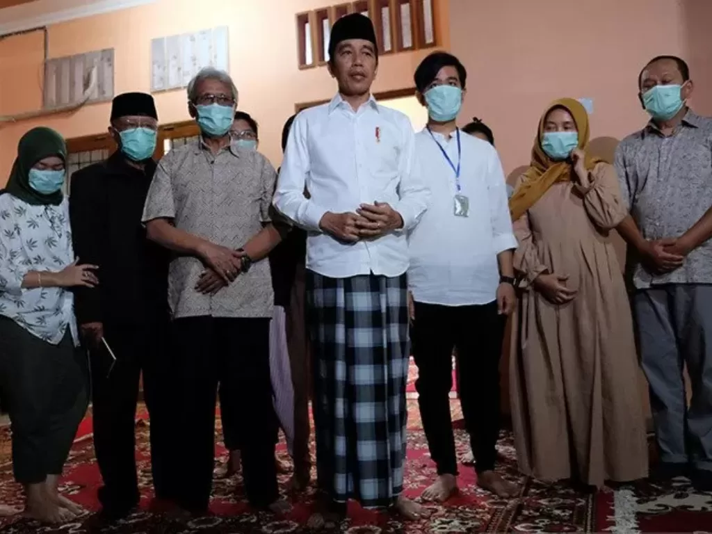 Presiden Jokowi (tengah) didampingi putra sulung presiden, Gibran (ketiga kanan) beserta keluarga di rumah duka di Solo, Jawa Tengah, Rabu (25/3/2020). (photo/ANTARAFOTO/Maulana Surya)