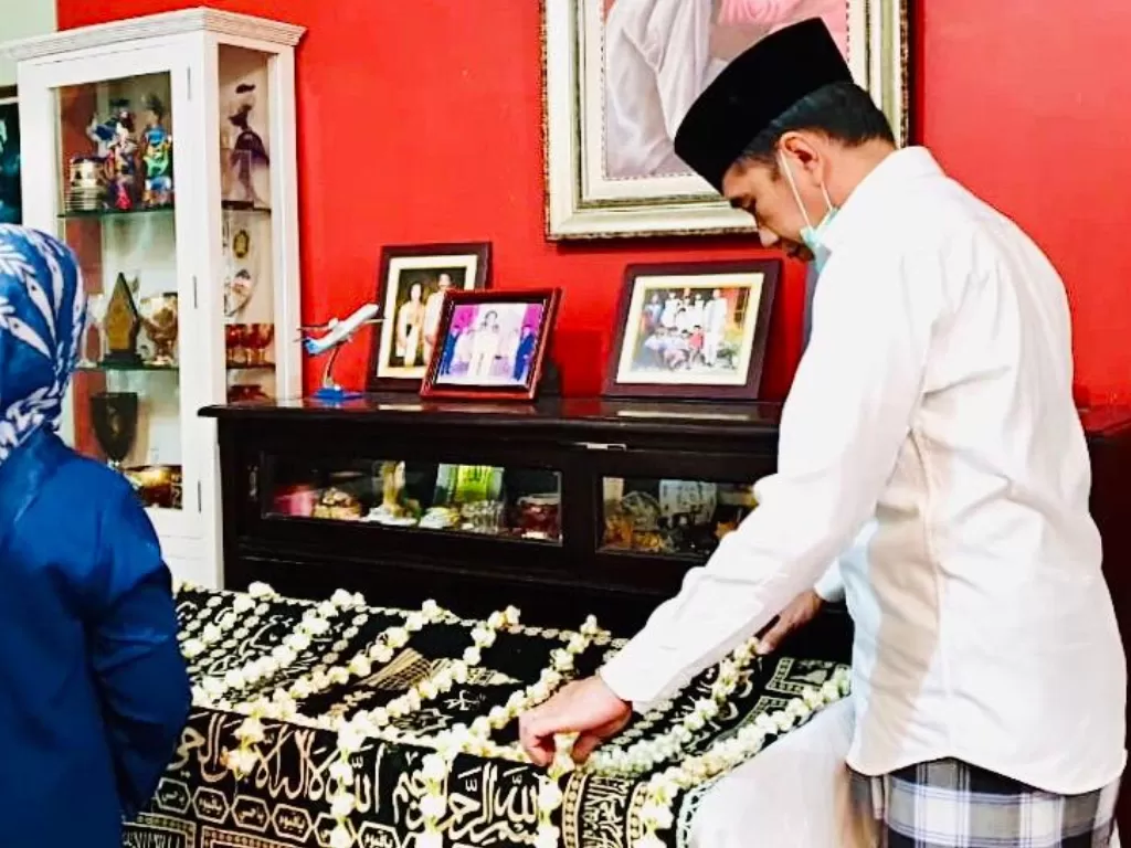 Presiden Jokowi meletakkan bunga di atas jenazah Ibundanya di rumah duka, Sumber, Banjarsari, Solo, Jawa Tengah, Rabu (25/3/2020). (BPMI Setpres)