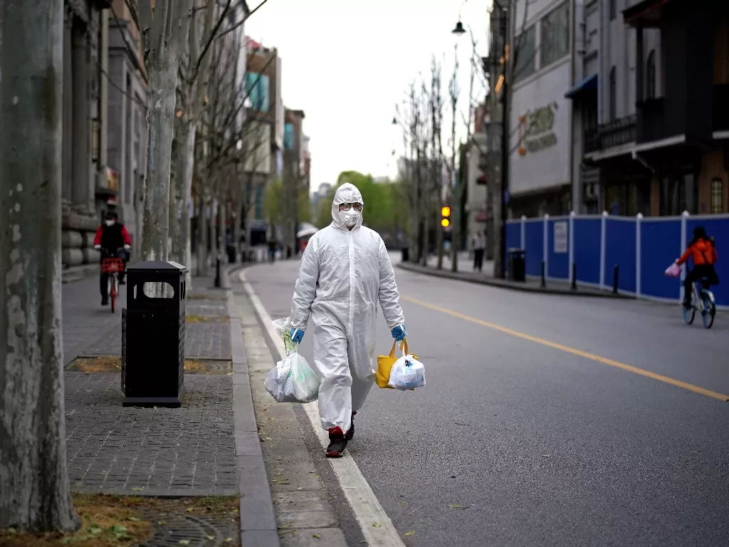 Warga Wuhan berjalan di jalanan yang sepi karena pandemi corona (REUTERS/Aly Song)