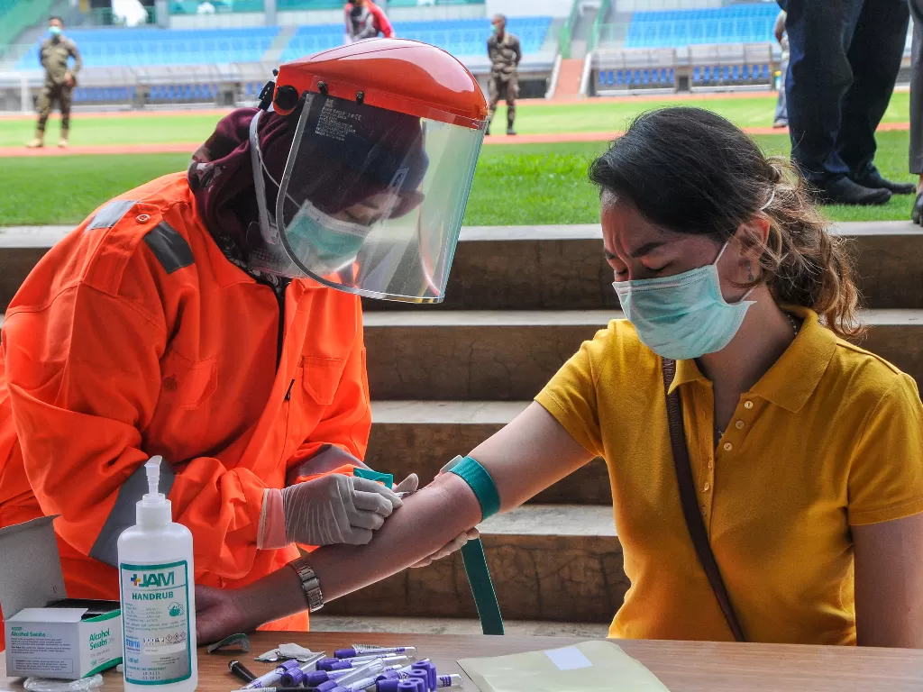 Petugas medis mengecek kesehatannya dengan mengambil sampel darah dengan metode rapid test (pemeriksaan cepat) di Stadion Patriot Candrabhaga, Bekasi, Jawa Barat, Rabu (25/3/2020). (ANTARA FOTO/ Fakhri Hermansyah)