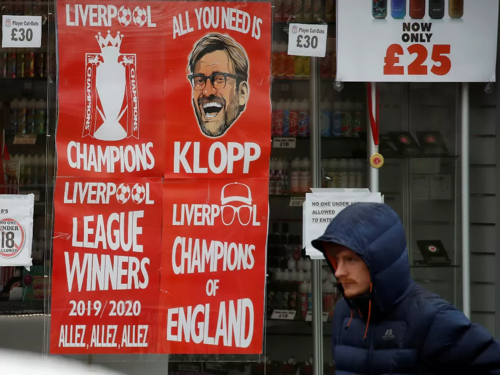 Warga melintas di depan poster Liverpool (REUTERS/Phil Noble)