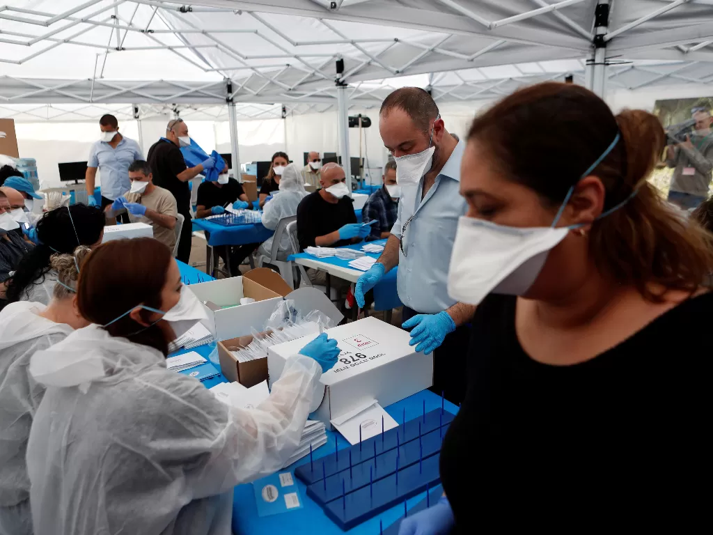 Staf medis di Israel bagikan masker untuk cegah virus corona. (REUTERS/Ronen Zvulun)