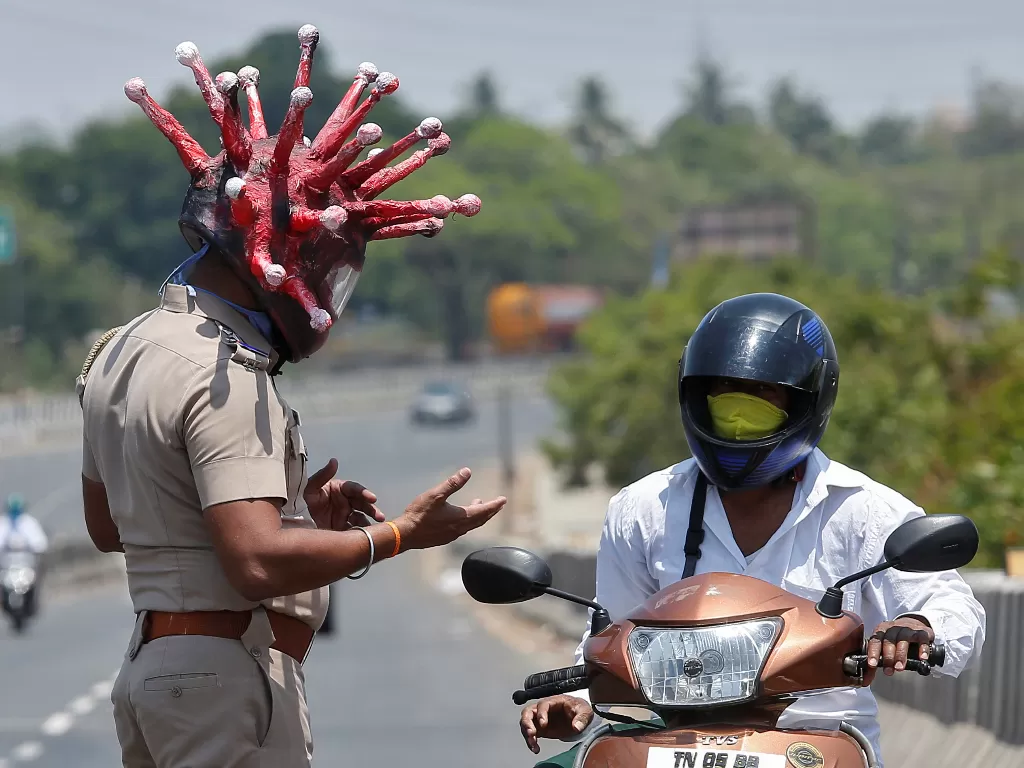 Polisi memakai helm Virus Corona. (REUTERS/P. Ravikumar)