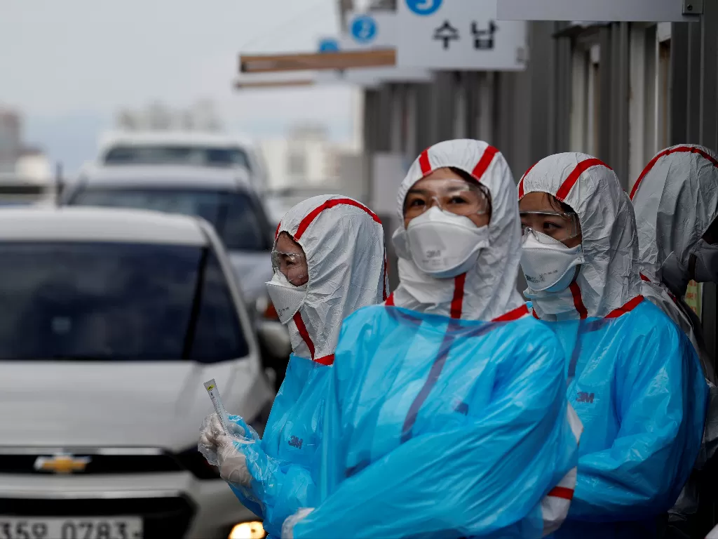 Staf medis dalam pekerjaan alat pelindung di pusat pengujian 'drive-thru' untuk penyakit coronavirus baru COVID-19 di Pusat Medis Universitas Yeungnam di Daegu. (photo/REUTERS/Kim Kyung-Hoon)