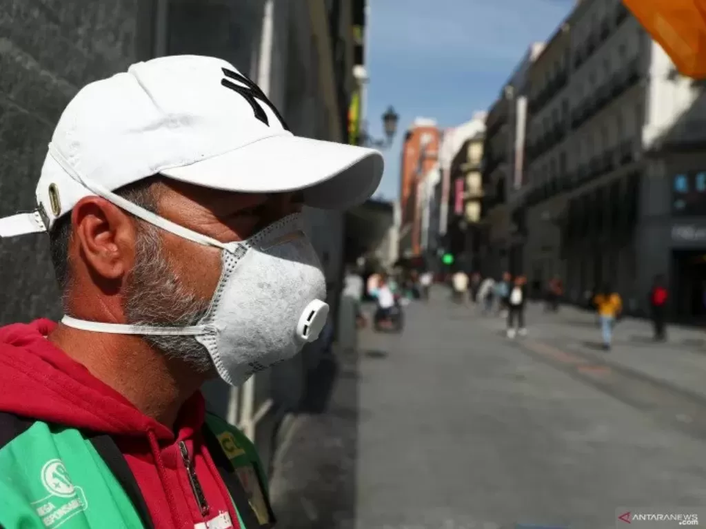 Penjual lotre kakilima Ignacio memakai masker pelindung saat menunggu pembeli di jalan Preciados yang sepi, tidak seperti biasanya, di pusat kota Madrid, Spanyol, Jumat (13/3/2020). ANTARA FOTO/REUTERS/Sergio Perez