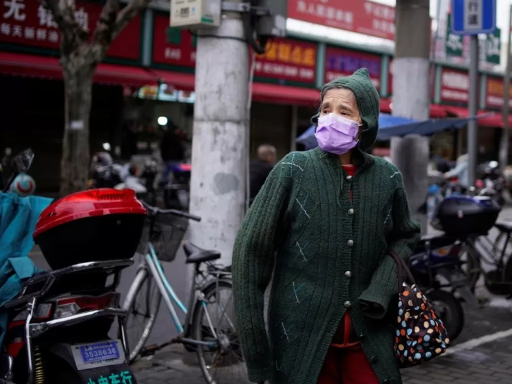 Seorang nenek memakai masker untuk mencegah terkena virus corona (REUTERS/Aly Song)