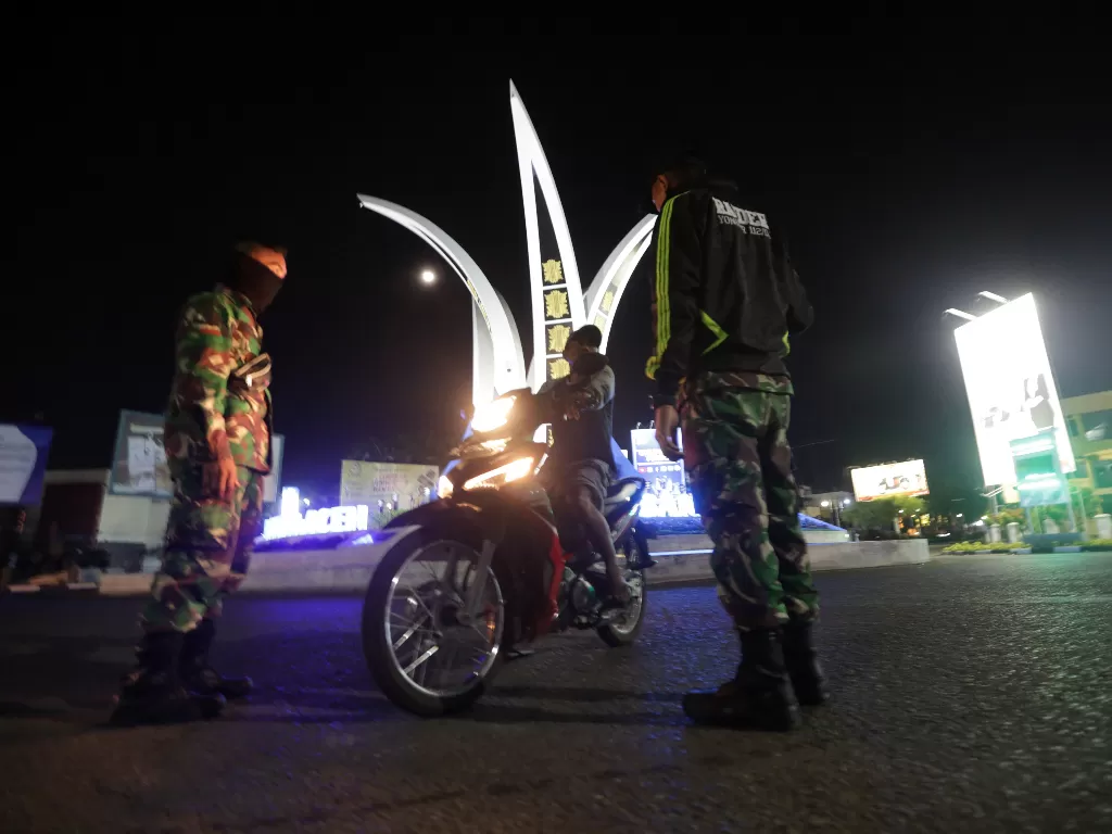  Potret petugas memberi arahan pada warga Aceh agar tak melanggar aturan jam malam. (ANTARA FOTO/Irwansyah Putra)