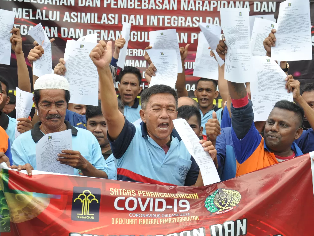 Sejumlah narapidana memperlihatkan surat pembebasan dari masa pidana di Lapas Kelas I Tanjung Gusta Medan, Sumatera Utara, Kamis (2/4/2020). (ANTARA FOTO/Septianda Perdana)