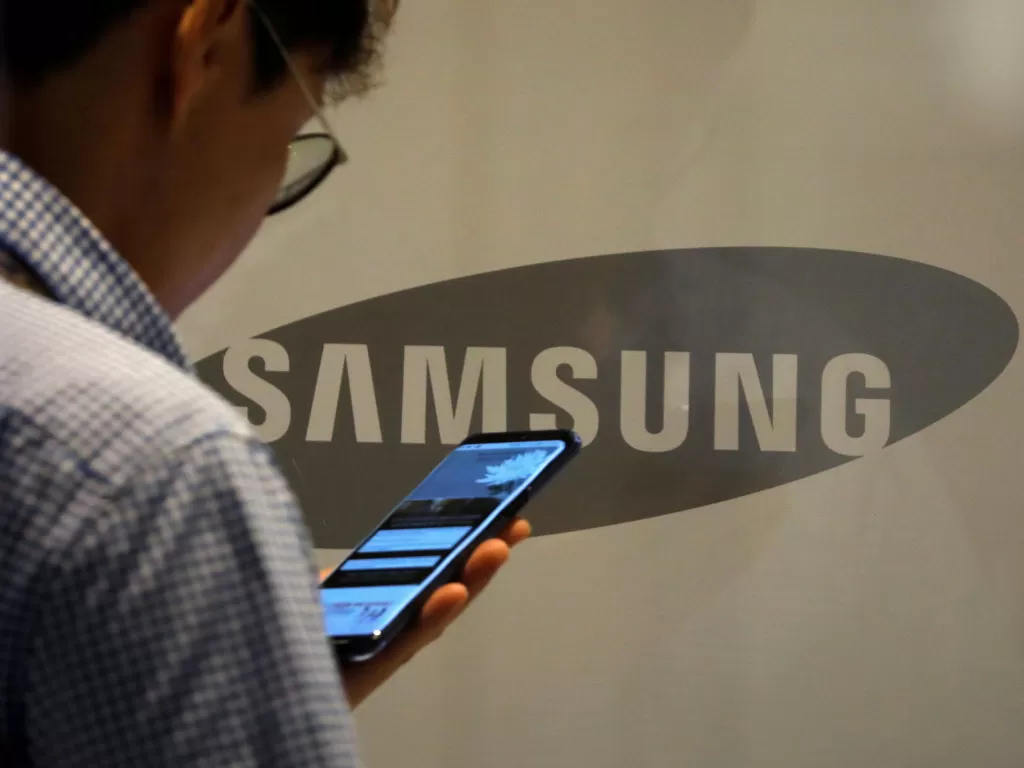 Seorang pria sedang menggunakan perangkat Samsung (photo/REUTERS/Kim Hong-Ji)