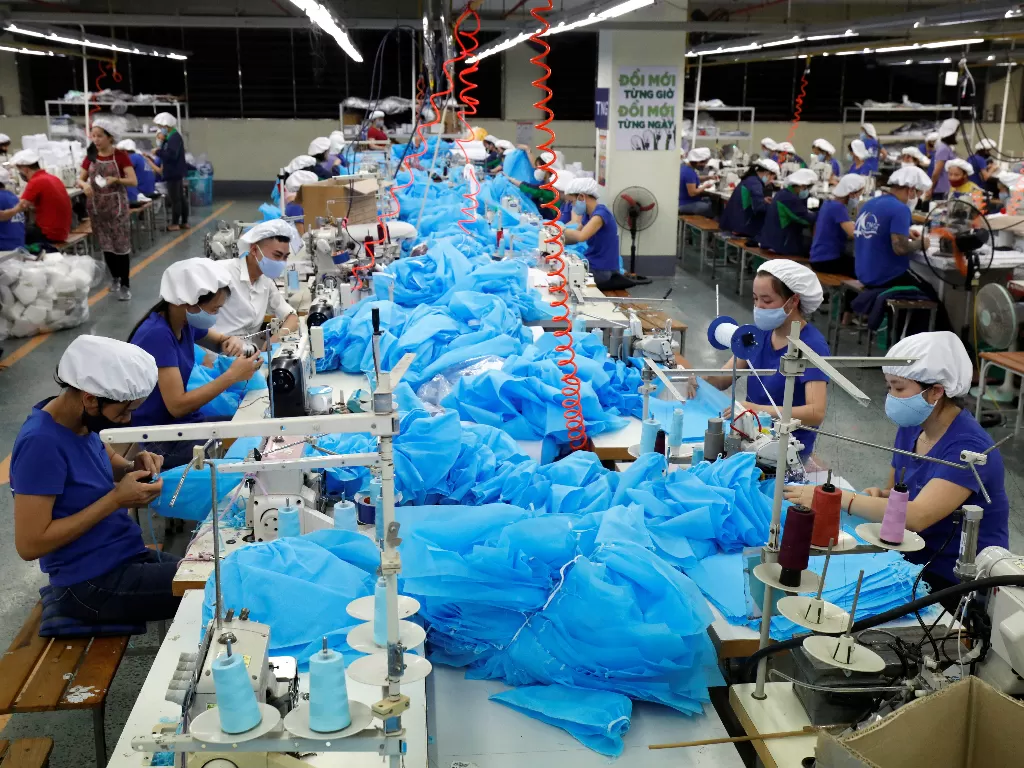 Para pekerja di Vietnam membuat masker dan APD untuk penanganan virus corona (REUTERS/Kham)
