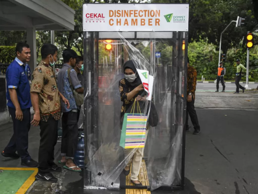 Pegawai berjalan keluar bilik disinfektan 'Disinfection Chamber' di Balai Kota, Jakarta, Kamis (26/3/2020). (ANTARA/Nova Wahyudi)