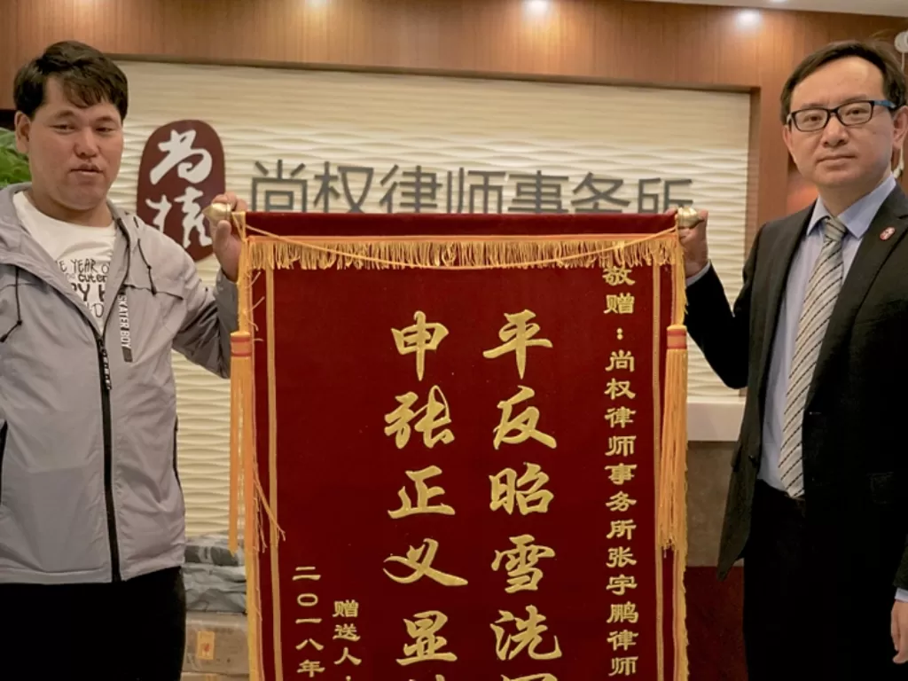 Liu Zhonglin (kiri) menerima kompensasi dari pemerintah. (Cgtn)
