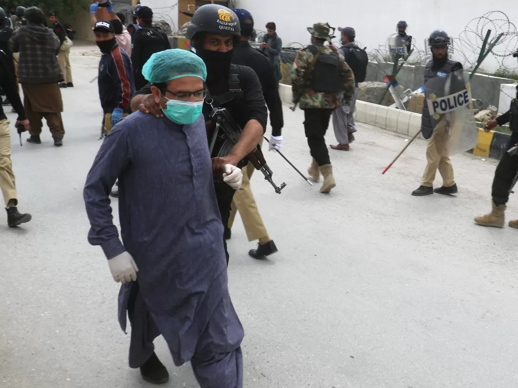 Seorang demonstran yang memprotes kekurangan APD di Pakistan diamankan polisi. (REUTERS/Naseer Ahmed)