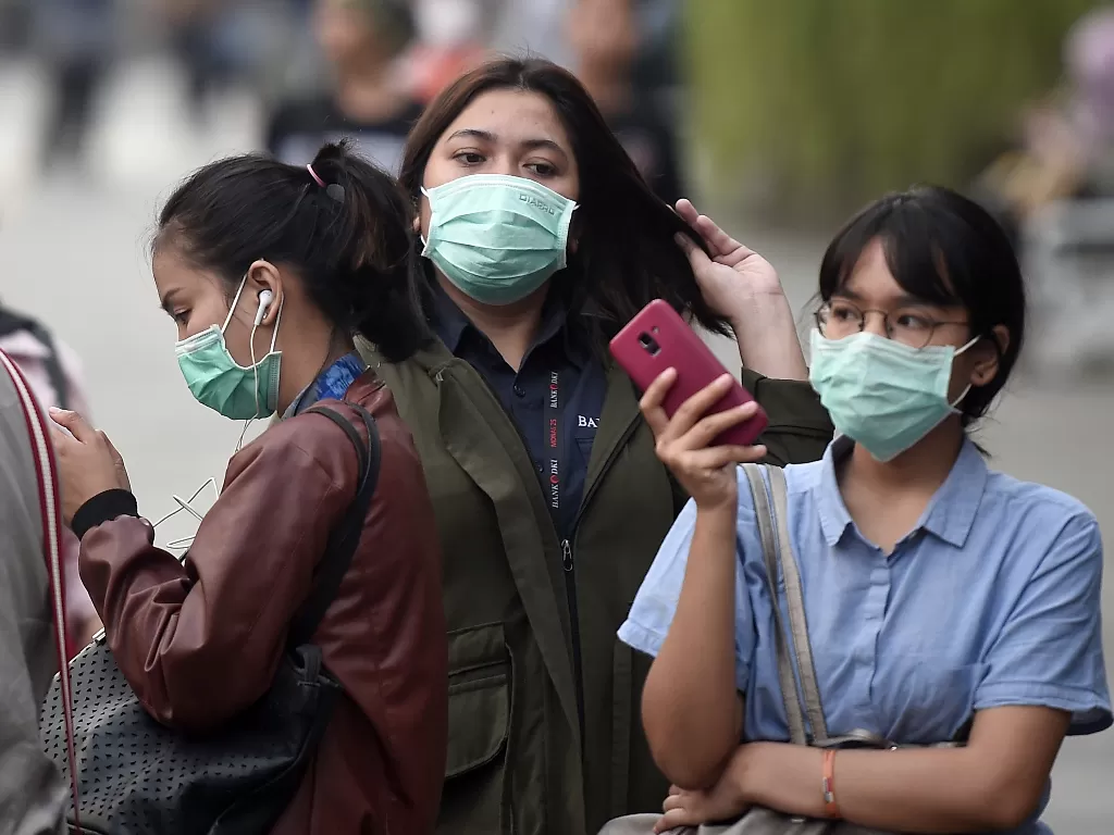 Orang-orang menggunakan masker untuk mencegah penularan virus corona (ANTARA FOTO/M Risyal Hidayat).