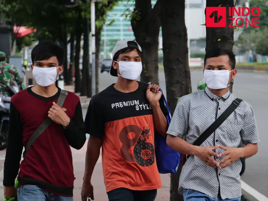 Warga berjalan menggunakan masker di kawasan Jalan M.H. Thamrin, Jakarta, Selasa (7/4/2020). (INDOZONE/Febio Hernanto)