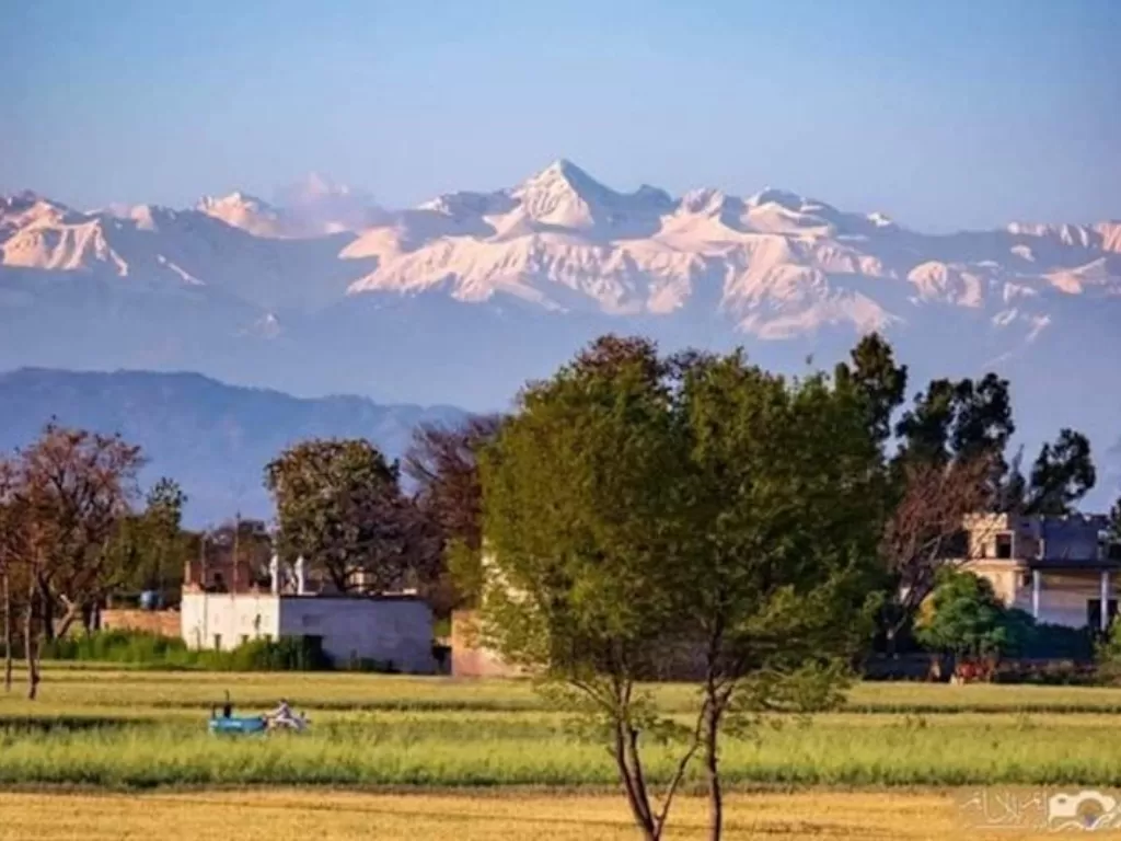 Pegunungan Himalaya yang bersalju terlihat dari sebuah desa di Punjab, India. (Twitter/Khawajaks)