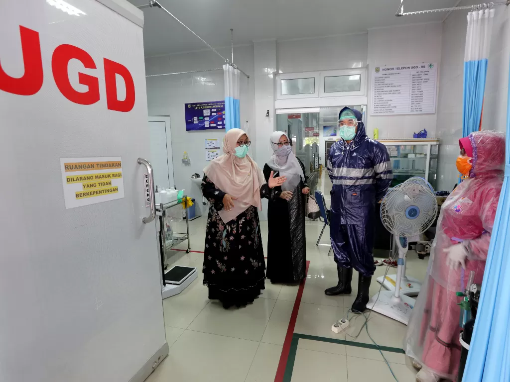 Petugas medis Puskesmas memakai jas hujan plastik sebagai Alat Pelindung Diri (APD) untuk melayani pasien virus corona di Banda Aceh, Aceh, Senin (6/4/2020). (ANTARA FOTO/Irwansyah Putra)