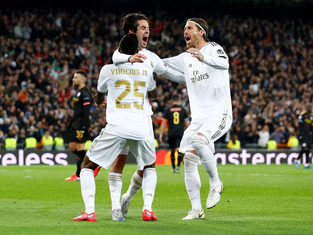 Tiga pemain Real Madrid, Isco, Vinicius Junior, dan Sergio Ramos melakukan selebrasi gol dalam leg pertama babak 16 besar Liga Champions kontra Manchester City. (REUTERS/Juan Medina)