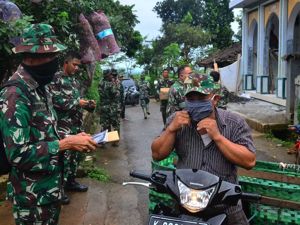 Anggota TNI membagikan masker kepada warga di Gebog, Kudus, Jawa Tengah. (ANTARA/Yusuf Nugroho)