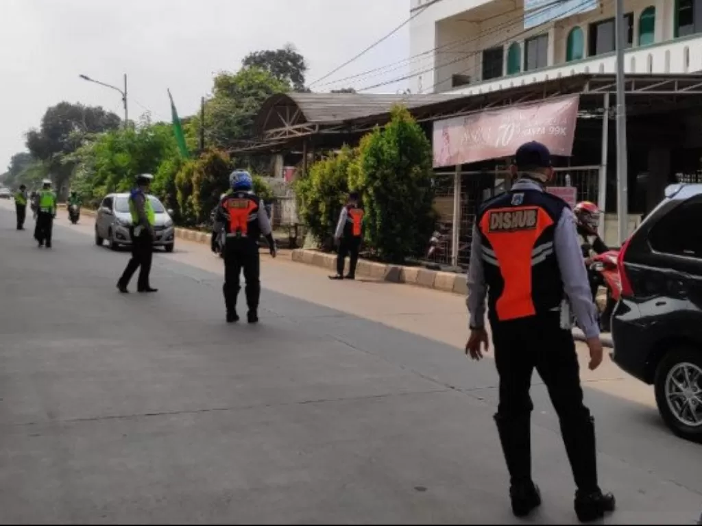 Petugas gabungan berjaga di wilayah perbatasan Jakarta Timur dan Depok tepatnya di Jalan Raya Bogor, Pasar Rebo, Jumat (10/4/2020). (ANTARA/Andi Firdaus)