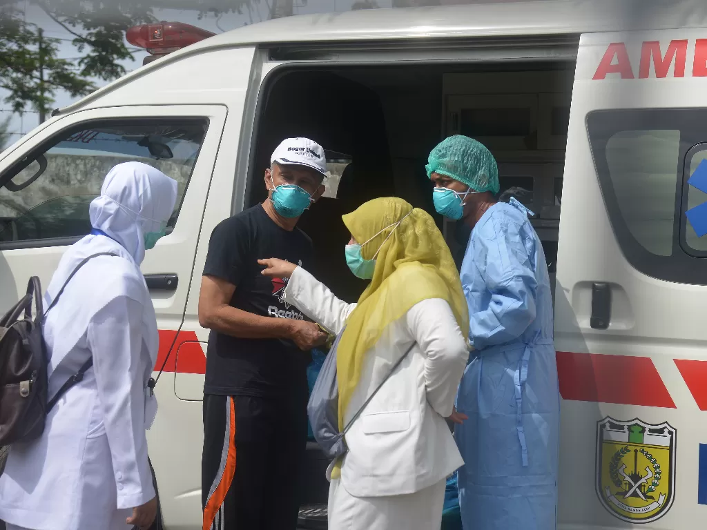 Seorang pasien positif COVID-19 (kedua kiri) yang dinyatakan sembuh bersiap menaiki mobil ambulan saat pemulangan di Rumah Sakit Zainal Abidin, Banda Aceh, Senin, (13/4/2020). (photo/ANTARA FOTO/Ampelsa)